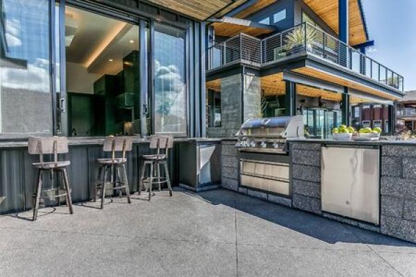 An outdoor kitchen just outside a home on a sunny day